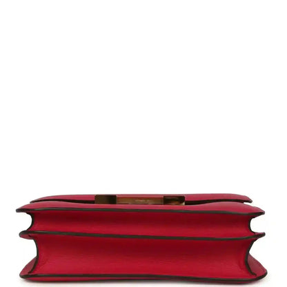 Red leather handbag underside view with side edges and gold-tone trim