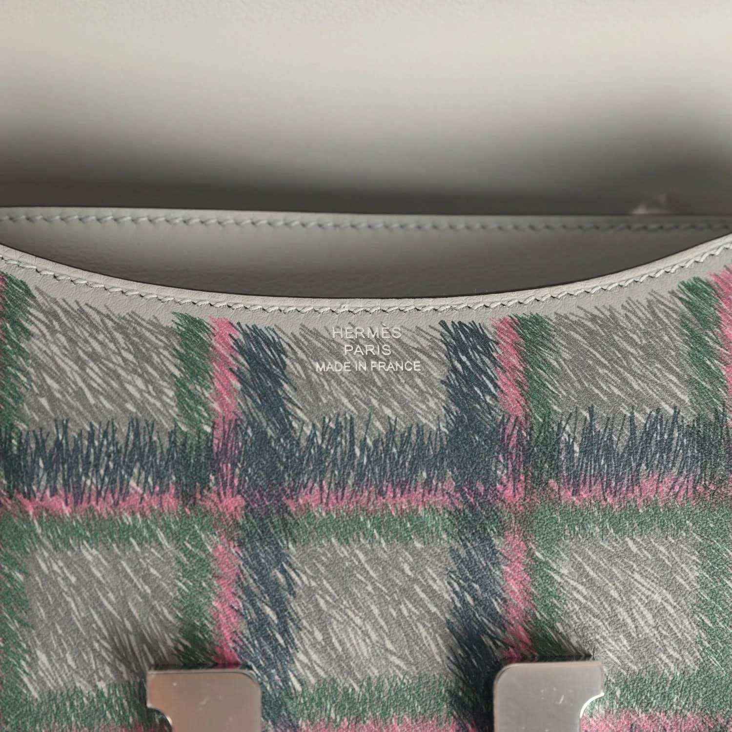 Plaid leather handbag interior stamp reading “Hermes Paris Made in France”