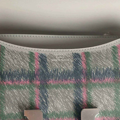 Plaid leather handbag interior stamp reading “Hermes Paris Made in France”
