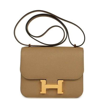 Tan leather crossbody bag with front flap and gold H clasp, top handle strap