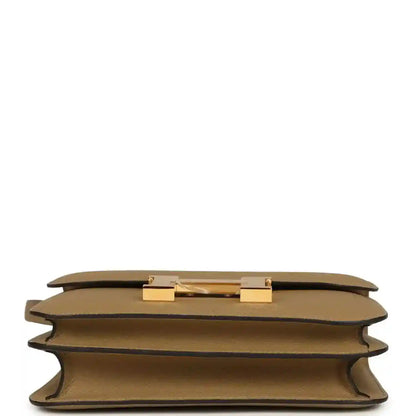 Tan leather bag underside with gold-tone hardware details and protective corner feet