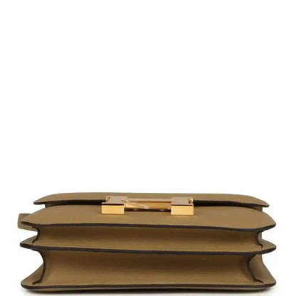 Tan leather bag underside with gold-tone hardware details and protective corner feet