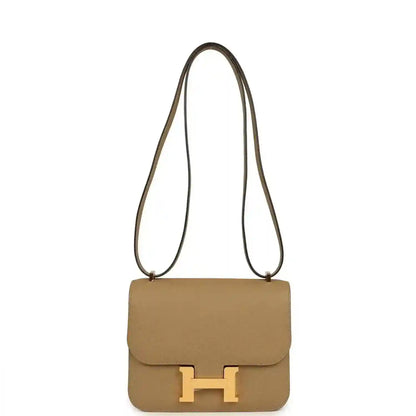 Tan leather mini crossbody bag with front flap and gold H clasp, long strap