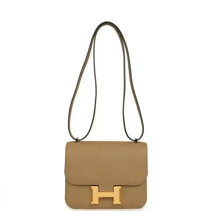 Tan leather mini crossbody bag with front flap and gold H clasp, long strap