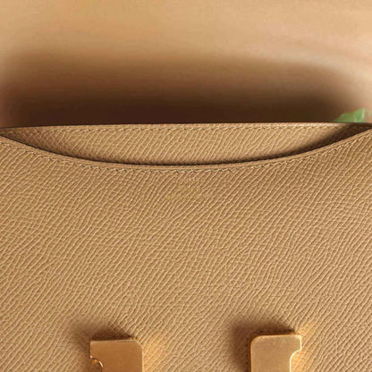 Tan leather interior lining with textured grain, small gold-tone clasp tabs