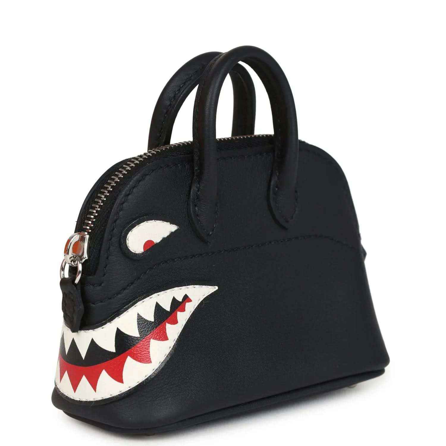 Black mini bag charm with gold zipper and shark mouth applique on side