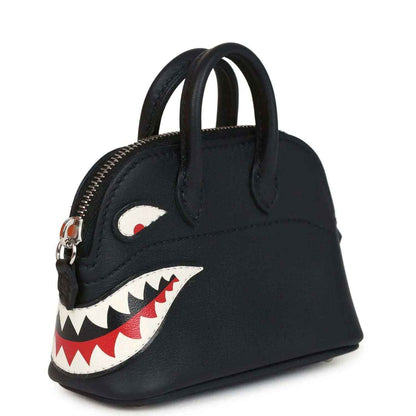 Black mini bag charm with gold zipper and shark mouth applique on side