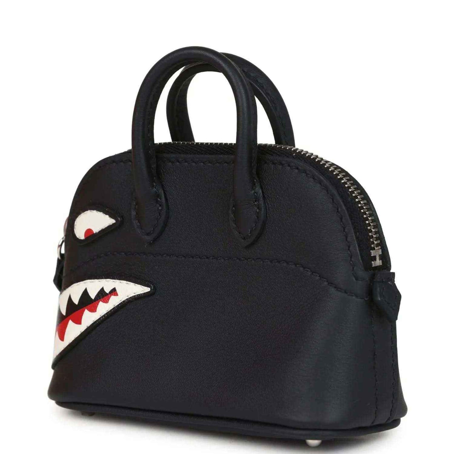Black mini bag charm with gold zipper, side shark eye patch, and mouth graphic