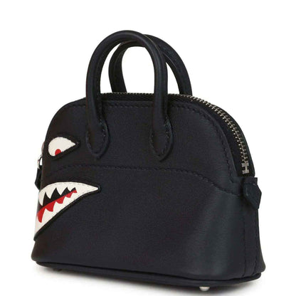 Black mini bag charm with gold zipper, side shark eye patch, and mouth graphic