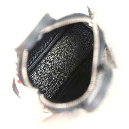 Black mini bag charm opening with textured interior lining and zipper area