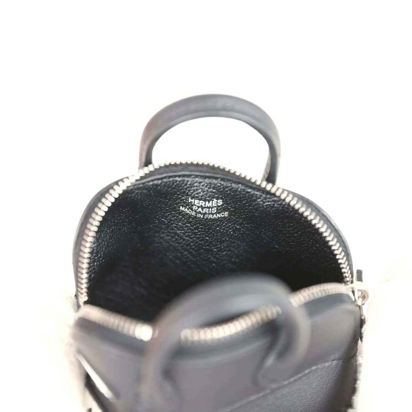 Black mini bag charm with Hermes Paris marking inside near zipper top