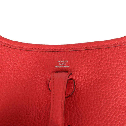 Red leather mini handbag interior stamp area with small leather tab detail.