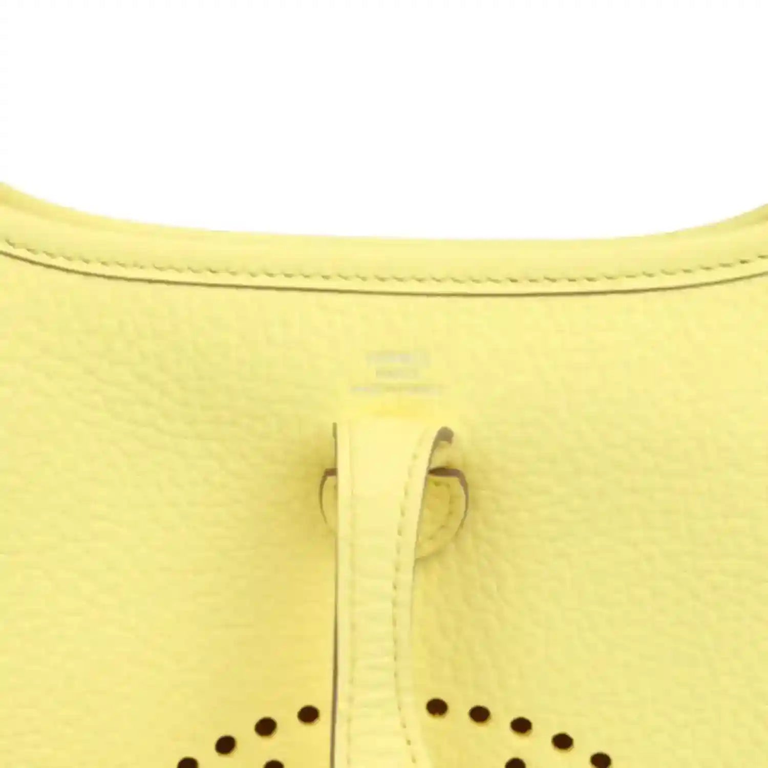 Close-up of lemon-yellow leather shoulder bag seam and stitched trim