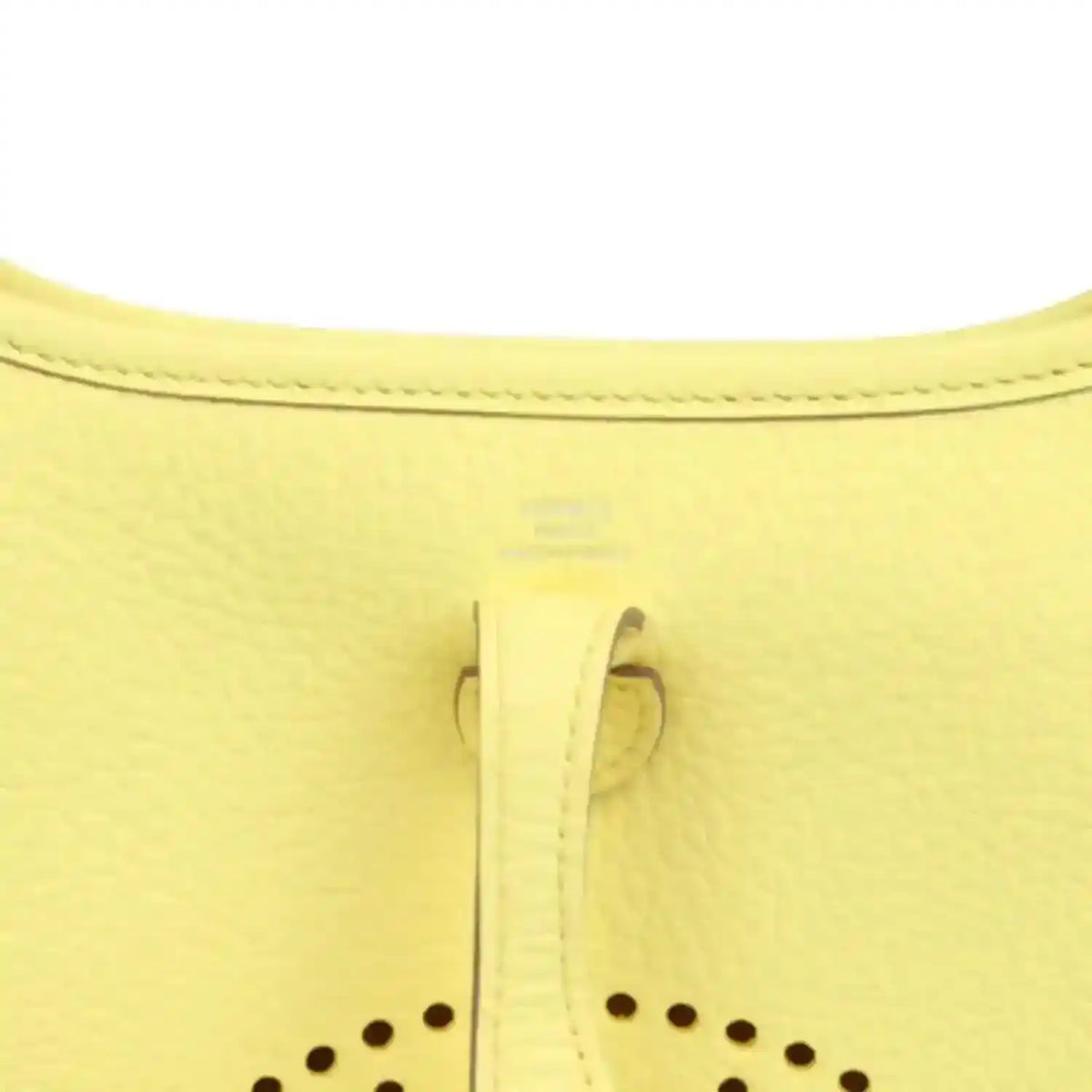 Close-up of lemon-yellow leather shoulder bag seam and stitched trim