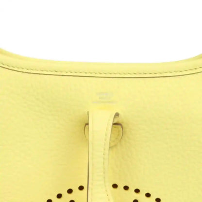 Close-up of lemon-yellow leather shoulder bag seam and stitched trim