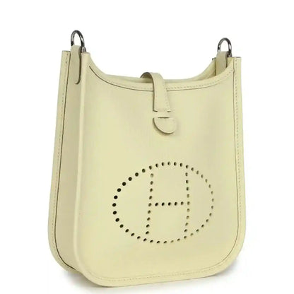 Light yellow leather mini crossbody bag with perforated 'E' logo and strap
