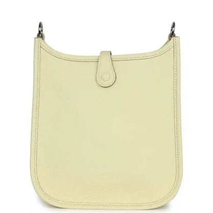 Light yellow leather mini crossbody bag with clean front panel and top loop