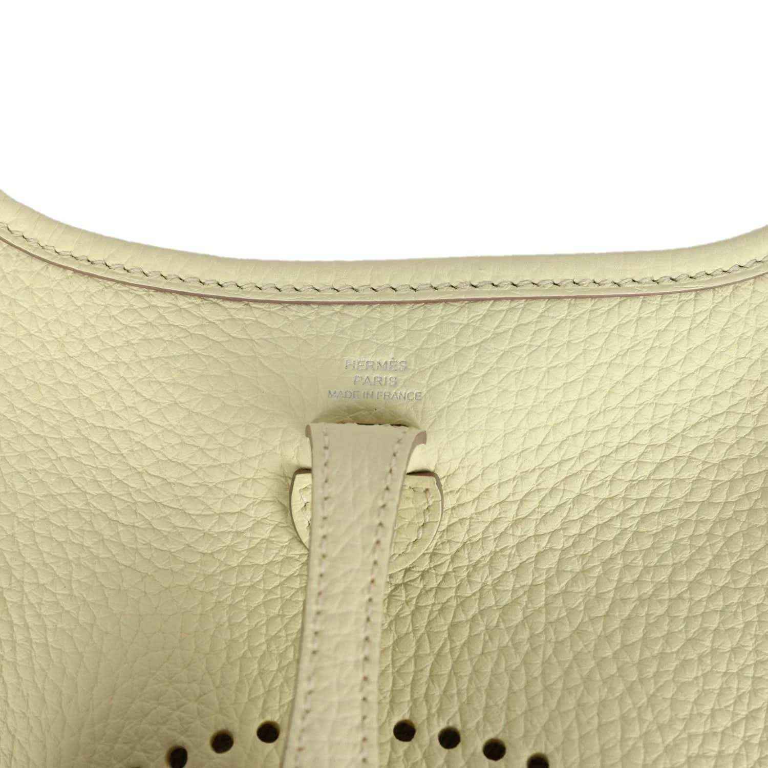 Light yellow leather mini crossbody bag close-up of top strap and stitching