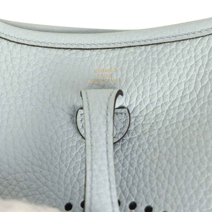 Evelyne TPM bag close-up: pale blue leather tab with printed marking and stitching
