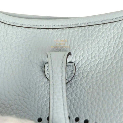 Evelyne TPM bag close-up: pale blue leather tab with printed marking and stitching