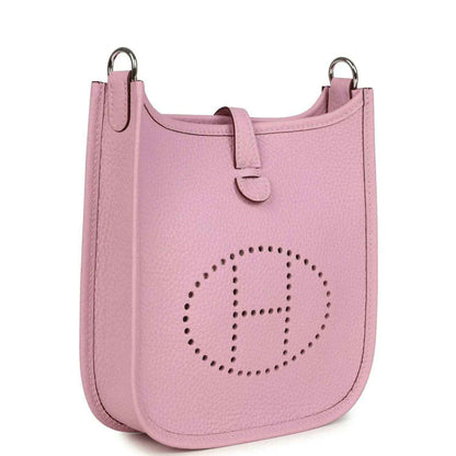 Mauve-pink leather crossbody bag with perforated front logo and top ring handles