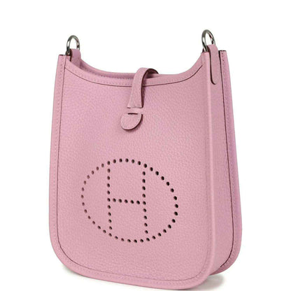 Mauve-pink leather crossbody bag angled view with perforated logo on front