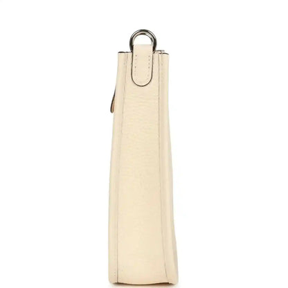 Cream textured leather bag with top handle and narrow side profile