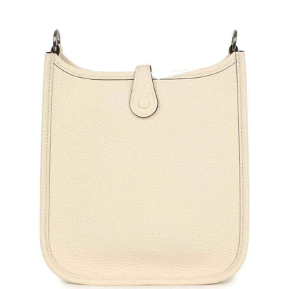 Cream textured leather bag with top loop and center strap tab