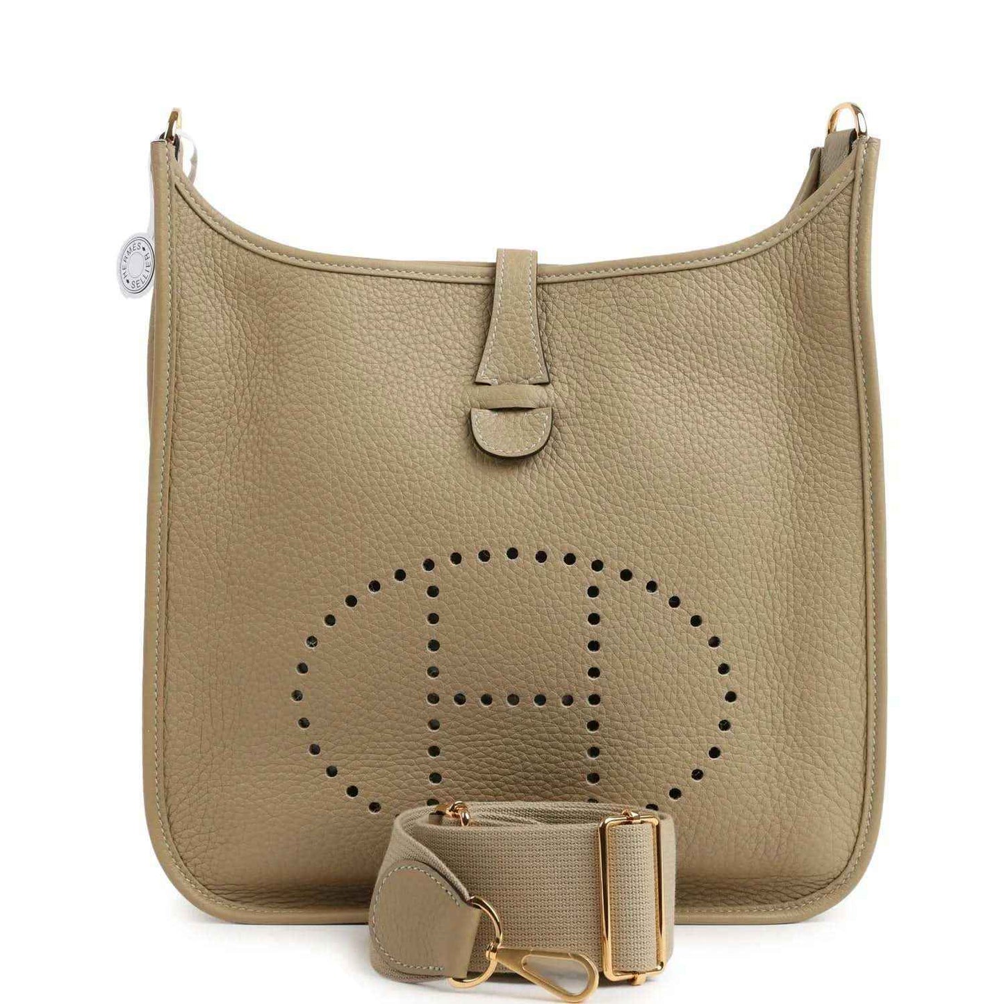 Small tan leather shoulder bag with perforated logo panel, front tab, and gold hardware