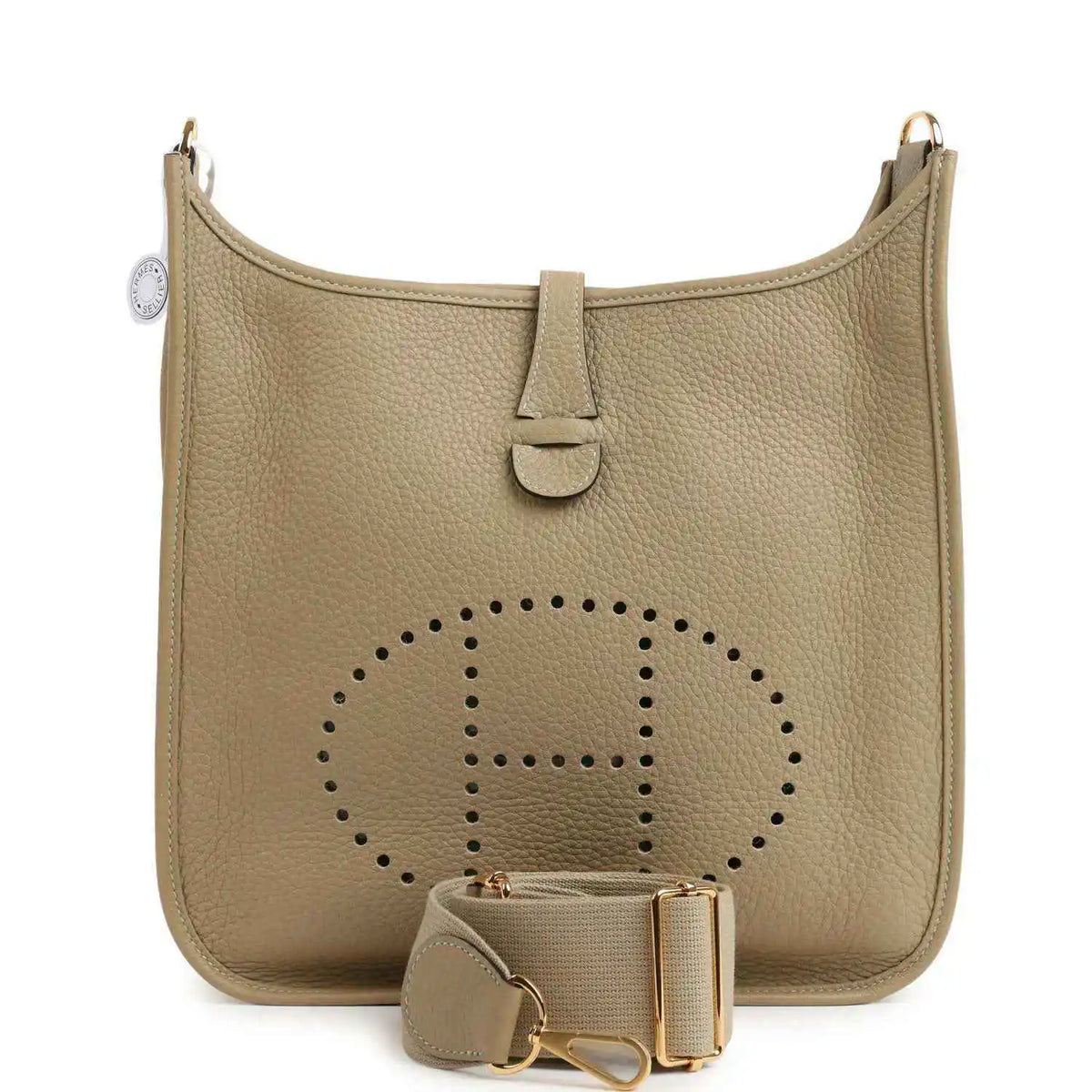 Small tan leather shoulder bag with perforated logo panel, front tab, and gold hardware