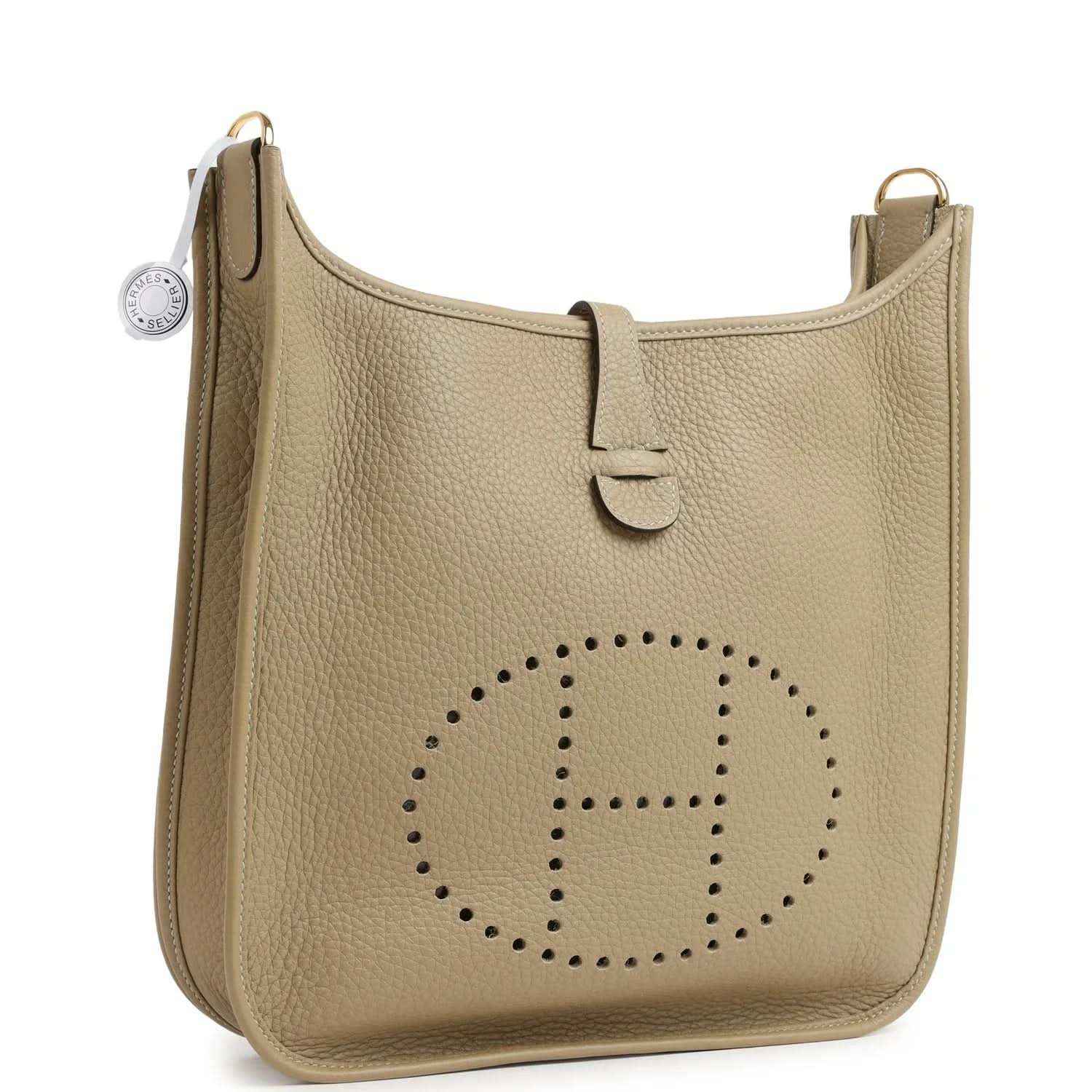 Small tan leather shoulder bag with perforated logo and adjustable strap at side ring