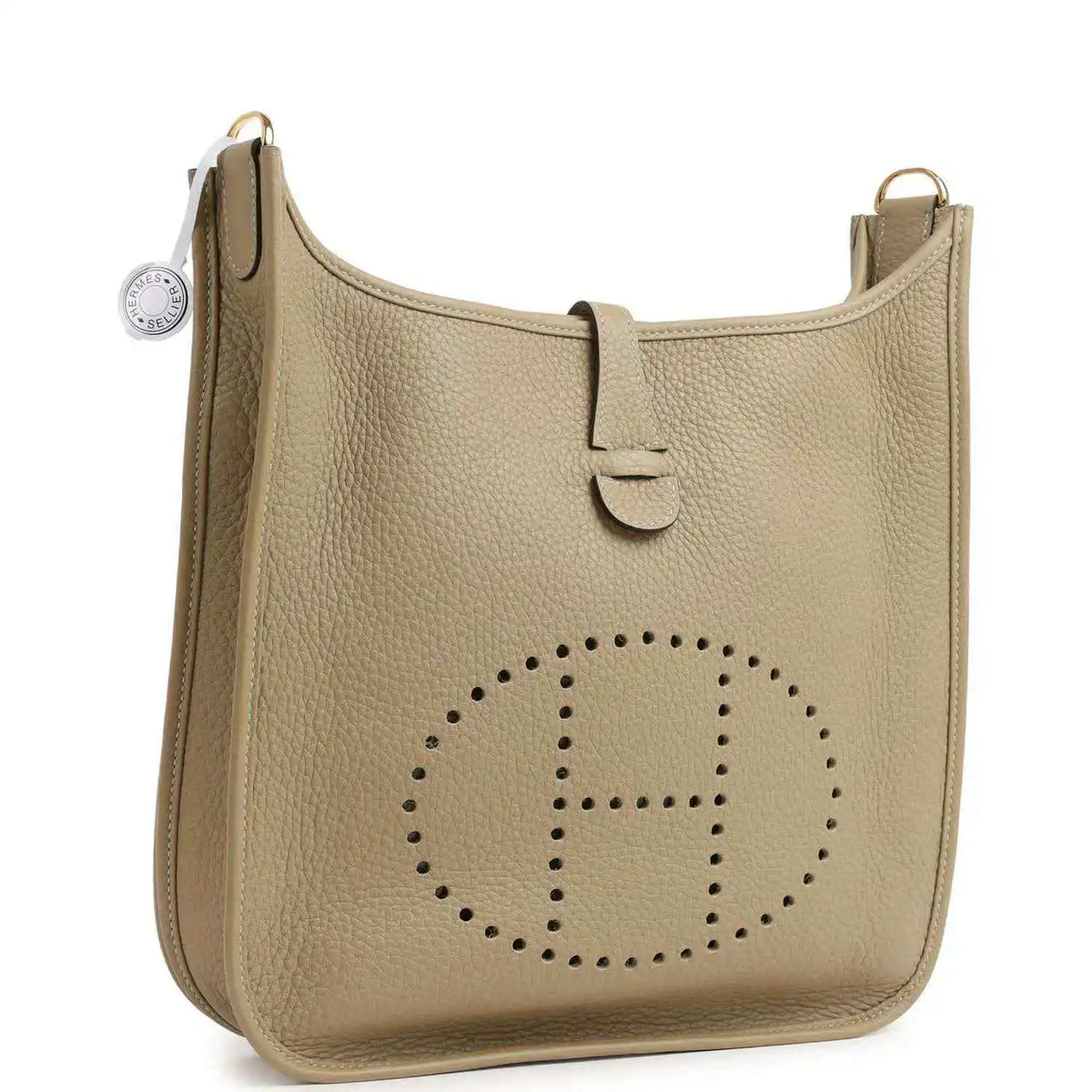 Small tan leather shoulder bag with perforated logo and adjustable strap at side ring