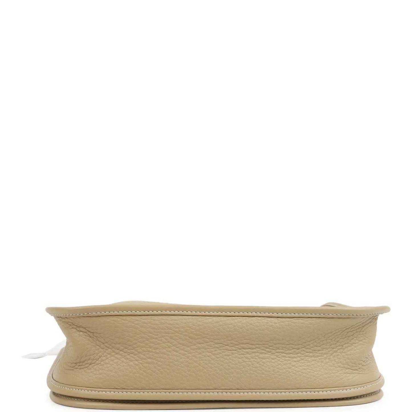 Small tan textured leather shoulder bag side view with flat base and gold-toned trim