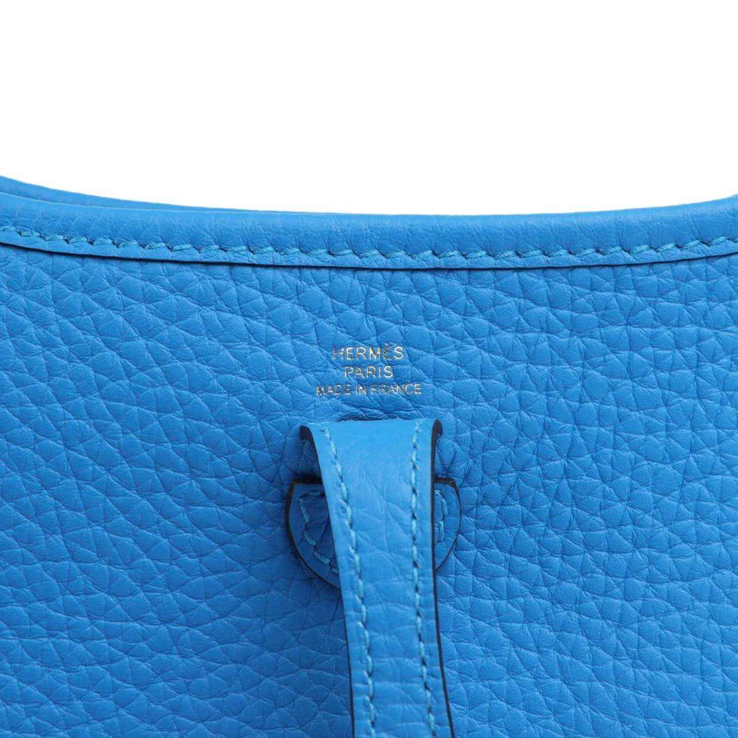 Blue leather bag with Hermes Paris stamp and stitched fold-over tab on the flap.