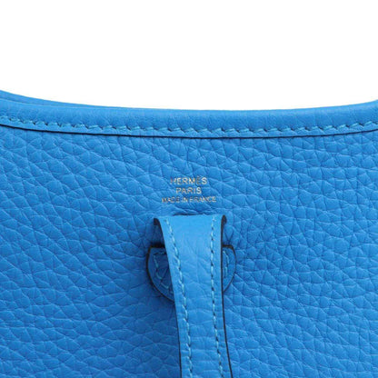 Blue leather bag with Hermes Paris stamp and stitched fold-over tab on the flap.