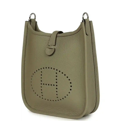 Sage green leather crossbody bag with perforated Evelyne logo and top rings