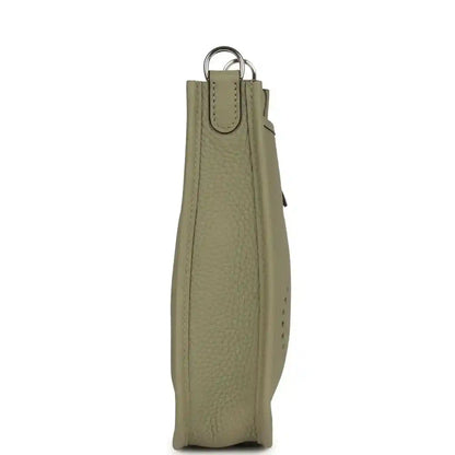 Sage green leather crossbody bag with hanging strap and silver-tone rings