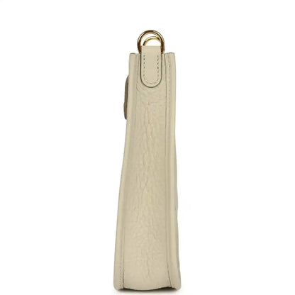 Hermes Evelyne TPM mini bag side view in light beige leather with gold top handle
