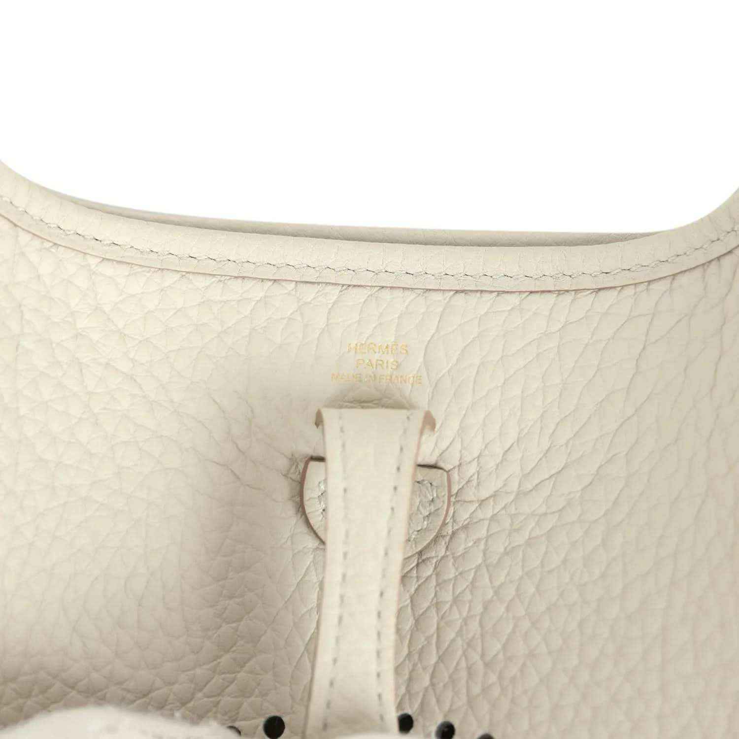 Hermes Evelyne TPM mini bag close-up of light beige textured leather and center tab