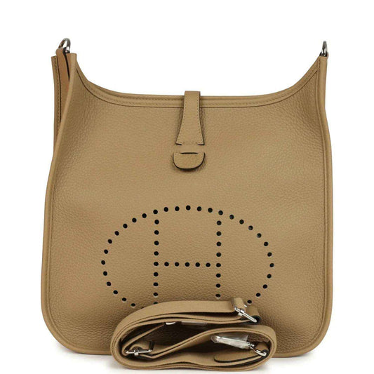 Tan leather hobo crossbody bag with perforated logo and front zipper pull