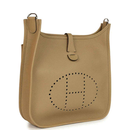 Tan leather hobo crossbody bag with perforated logo and top handle loop
