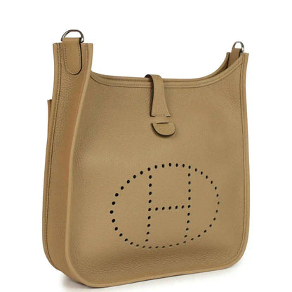 Tan leather hobo crossbody bag with perforated logo and top handle loop