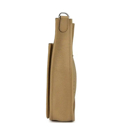 Tan leather hobo crossbody bag shown from the side with top handle loop