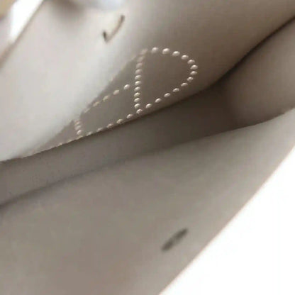Light beige leather bag interior lining with stitched seam and logo-dotted detail