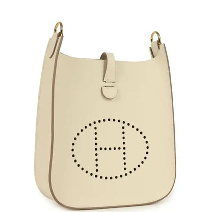 Cream leather crossbody bag with dotted 'H' logo and gold-tone top handles
