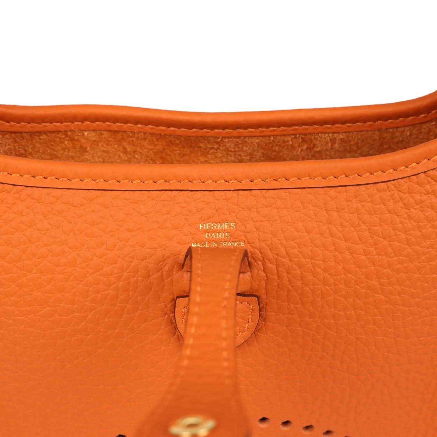 Hermes Paris orange leather tab and stitching at top opening of crossbody bag