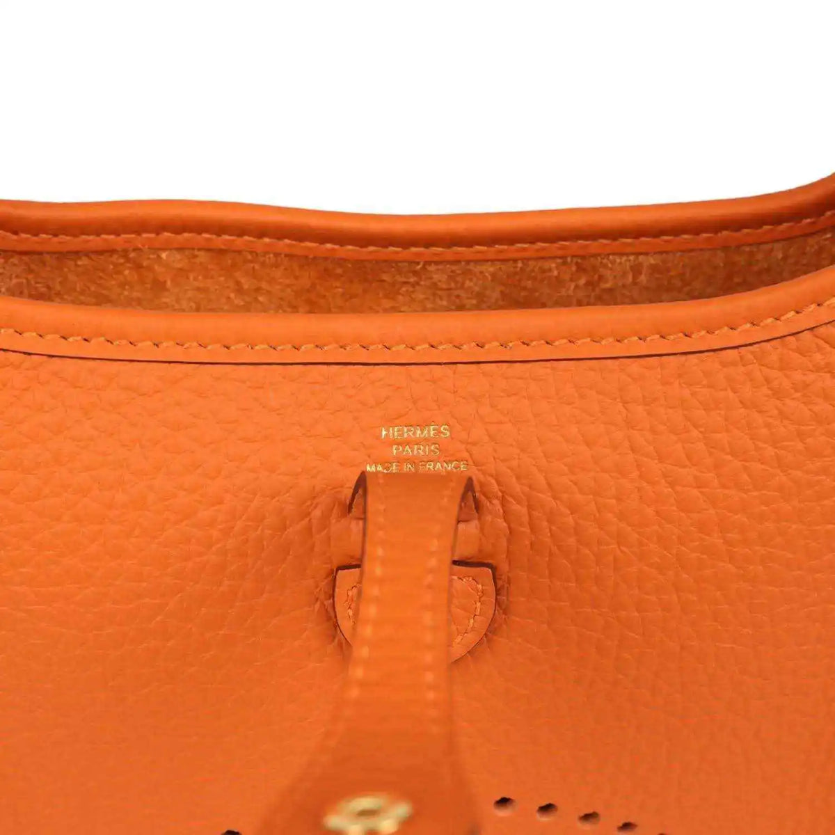 Hermes Paris orange leather tab and stitching at top opening of crossbody bag