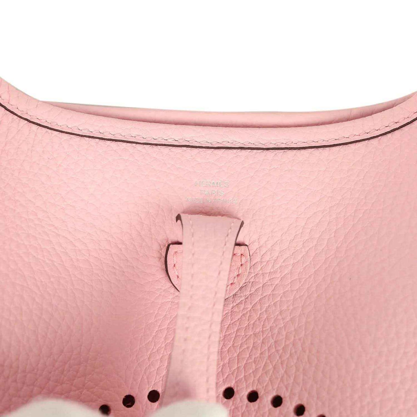 Rose pink leather Evelyne TPM bag close-up of top tab and dotted logo