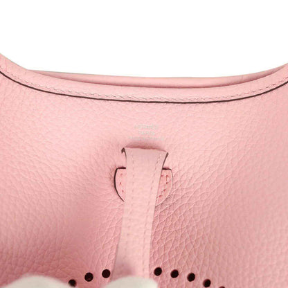 Rose pink leather Evelyne TPM bag close-up of top tab and dotted logo
