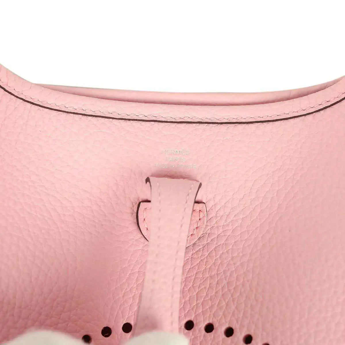 Rose pink leather Evelyne TPM bag close-up of top tab and dotted logo